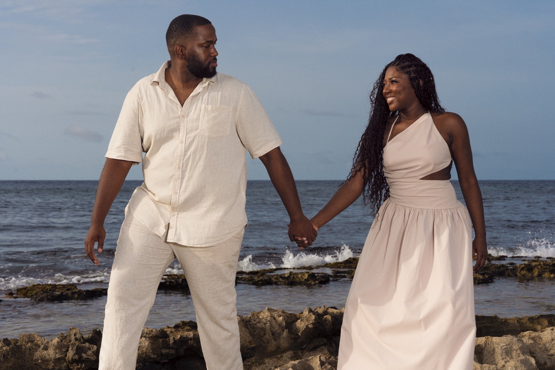 Chris and Shay holding hands by the sea